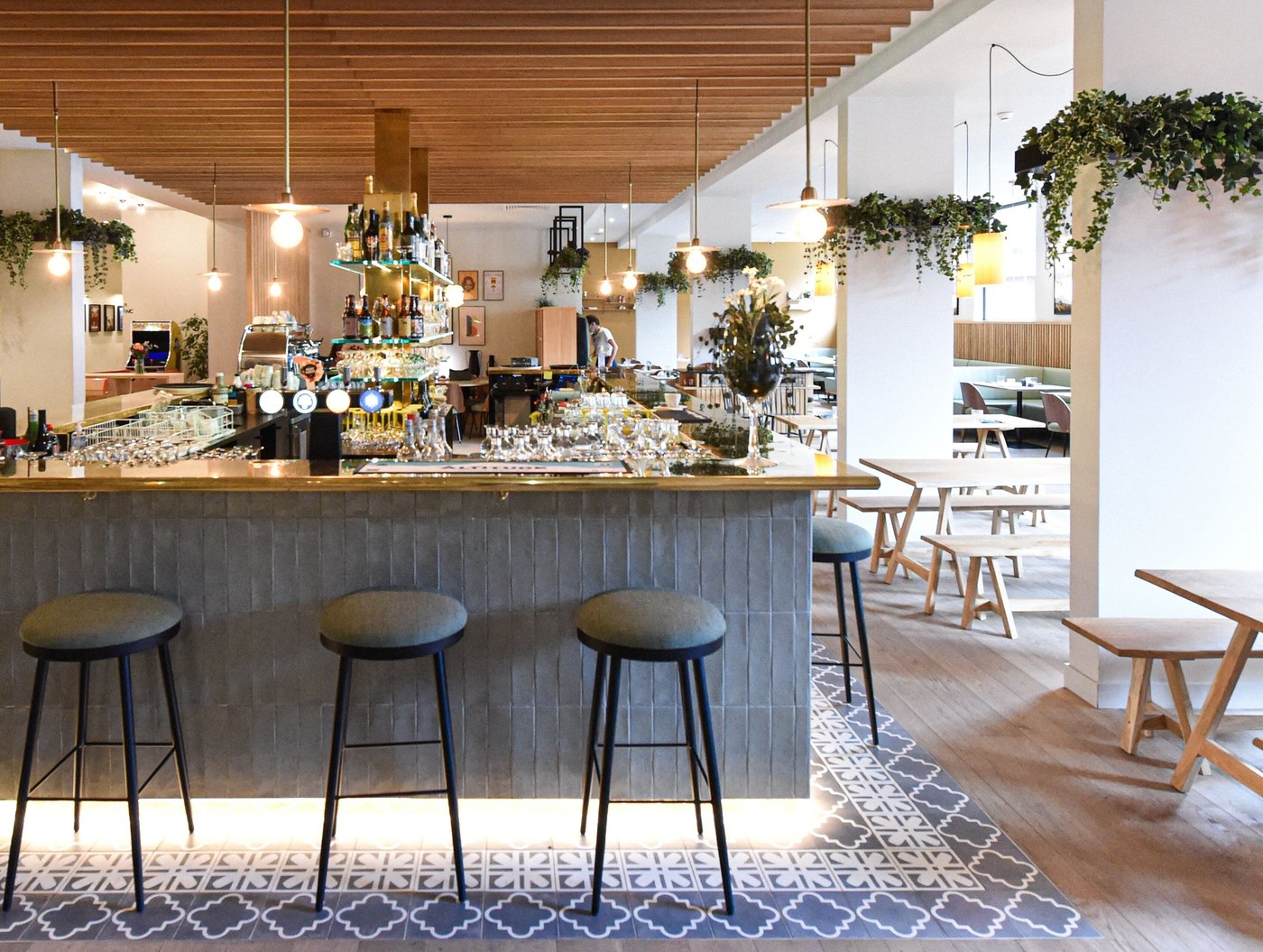 PlanB Living Chamonix bar with a wooden ceiling, counter seating and bottles displayed behind the bar.